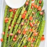 Homemade Olive Garden Parmesan Roasted Asparagus with balsamic drizzle and cheese sauce on a platter