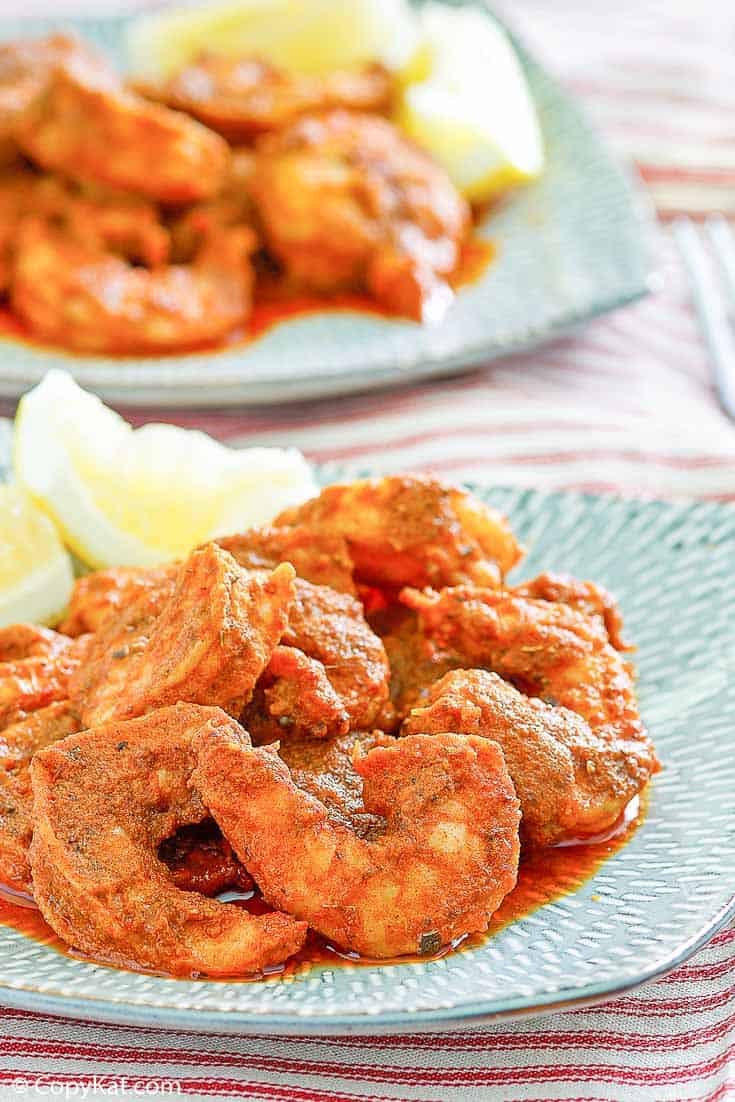 Homemade Red Lobster Cajun Shrimp and lemon wedges on a blue plate