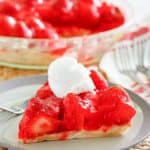 a slice of fresh strawberry pie with a dollop of whipped cream on top