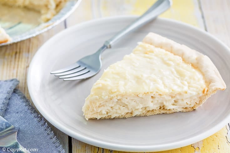 a slice of coconut cream pie and a fork on a plate