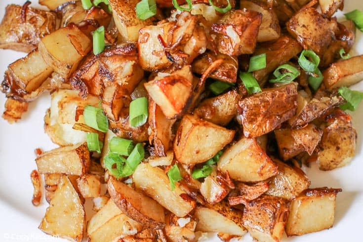 oven roasted potatoes topped with chopped green onions on a platter