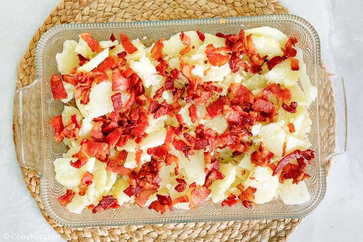 cooked sliced potatoes and bacon in a baking dish