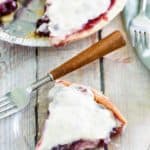 homemade sour cream blueberry pie slice on a plate next to the pie