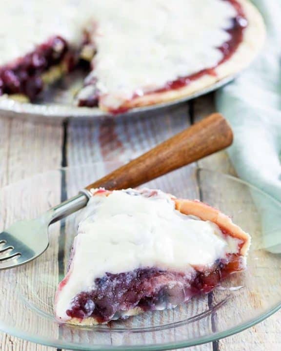 sour cream blueberry pie slice and a fork on a plate