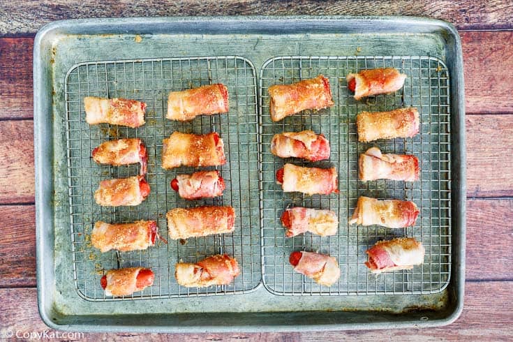 brown sugar bacon wrapped little smokies on racks in a baking sheet
