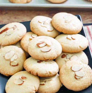 Chinese almond cookies on a platter and baking sheet