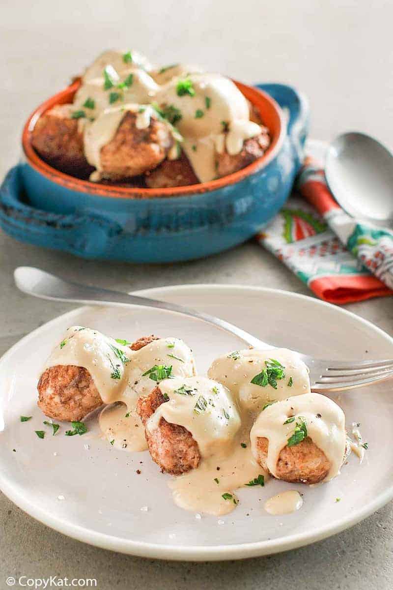 homemade Swedish meatballs and gravy on a plate and in a bowl