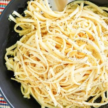 overhead view of a bowl of pasta with egg and parmesan cheese