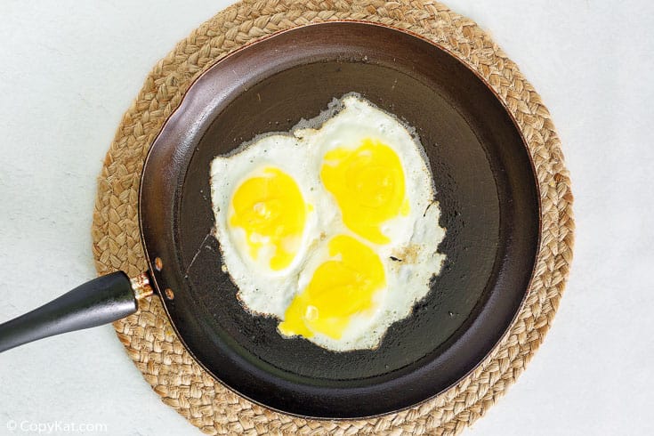 three fried eggs in a skillet