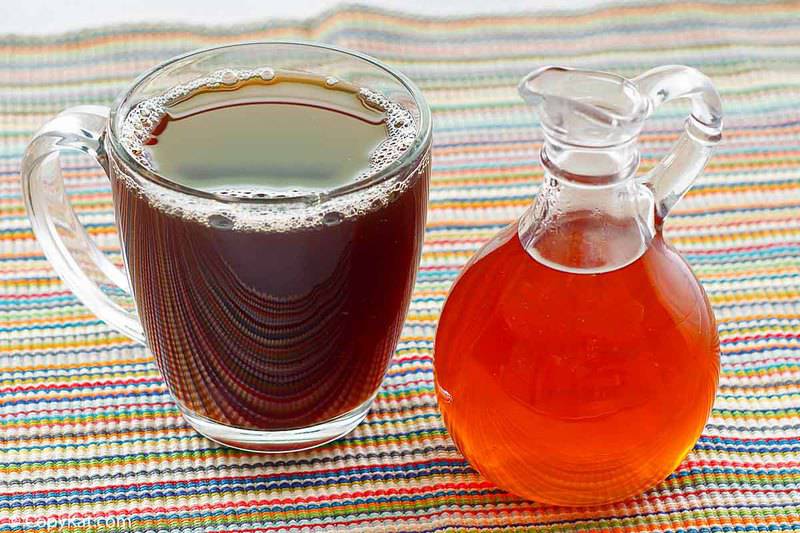 a container of caramel syrup and a cup of coffee