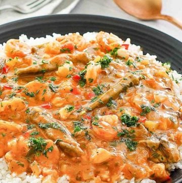 seafood gumbo over rice in a black bowl