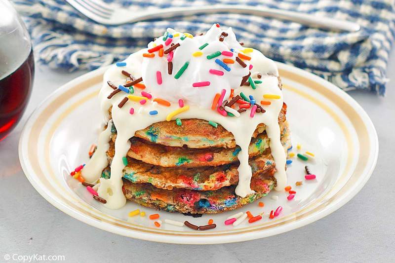 a stack of pancakes with sprinkles and icing