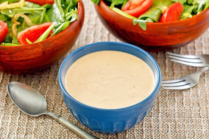 a small bowl of homemade Russian dressing and two salads