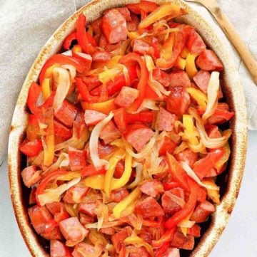 overhead view of smoked sausage and peppers in a serving dish