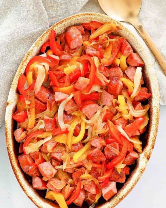 overhead view of smoked sausage and peppers in a serving dish