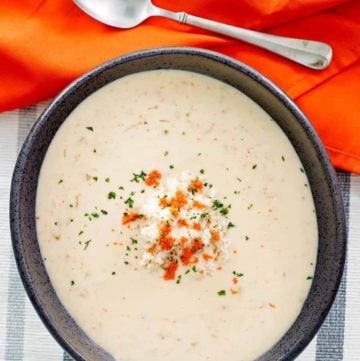 overhead view of a bowl of she crab soup, a napkin, and spoon