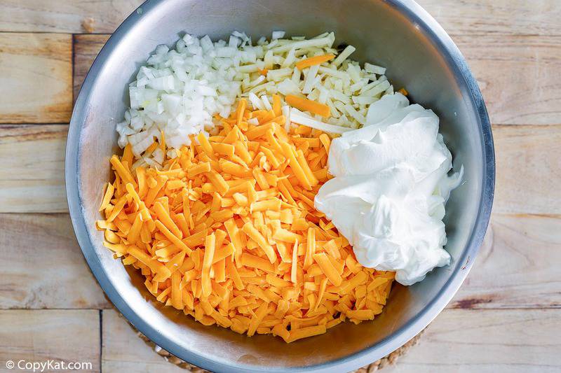 cheesy hashbrown casserole ingredients in a mixing bowl