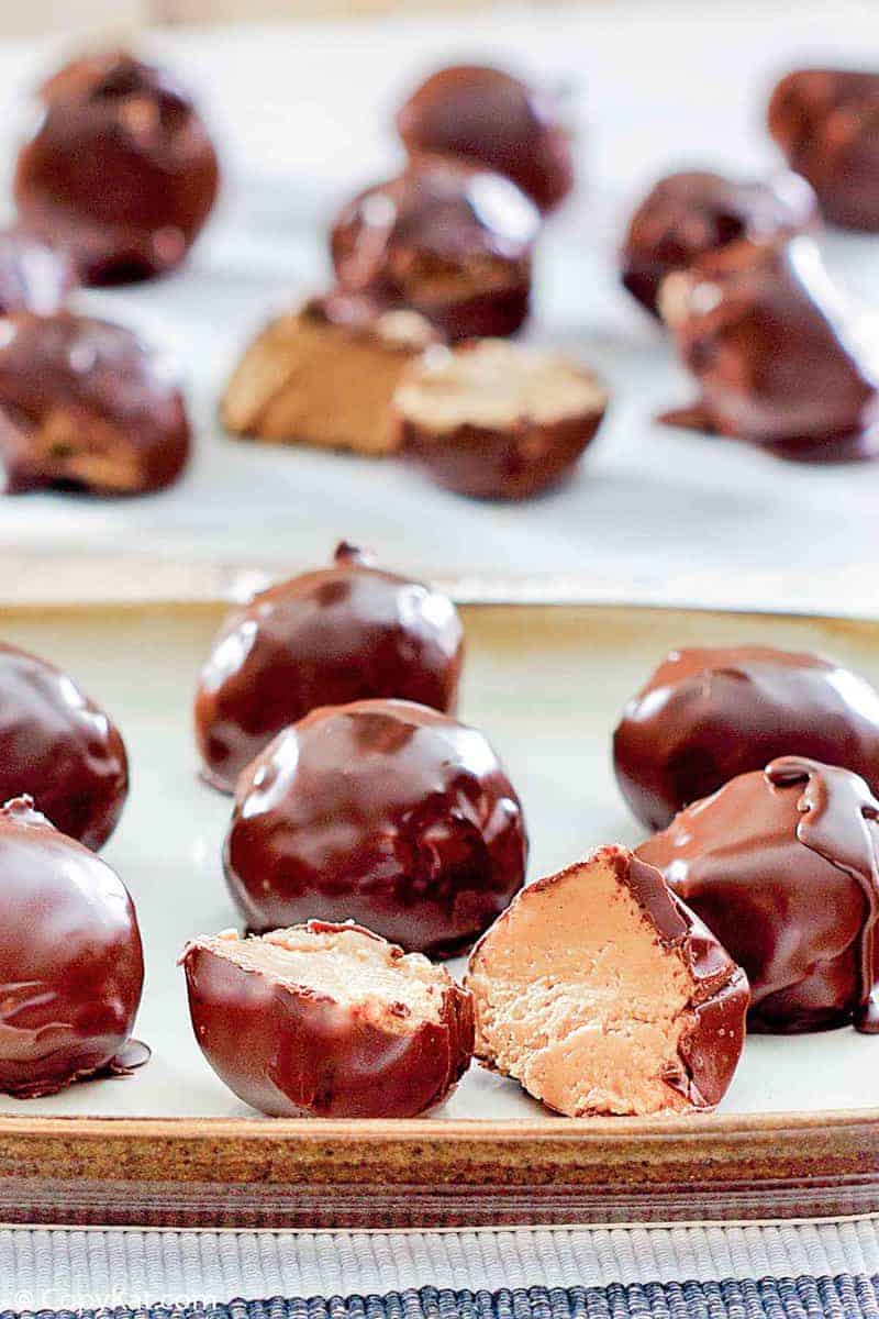 chocolate peanut butter balls on a plate and parchment paper