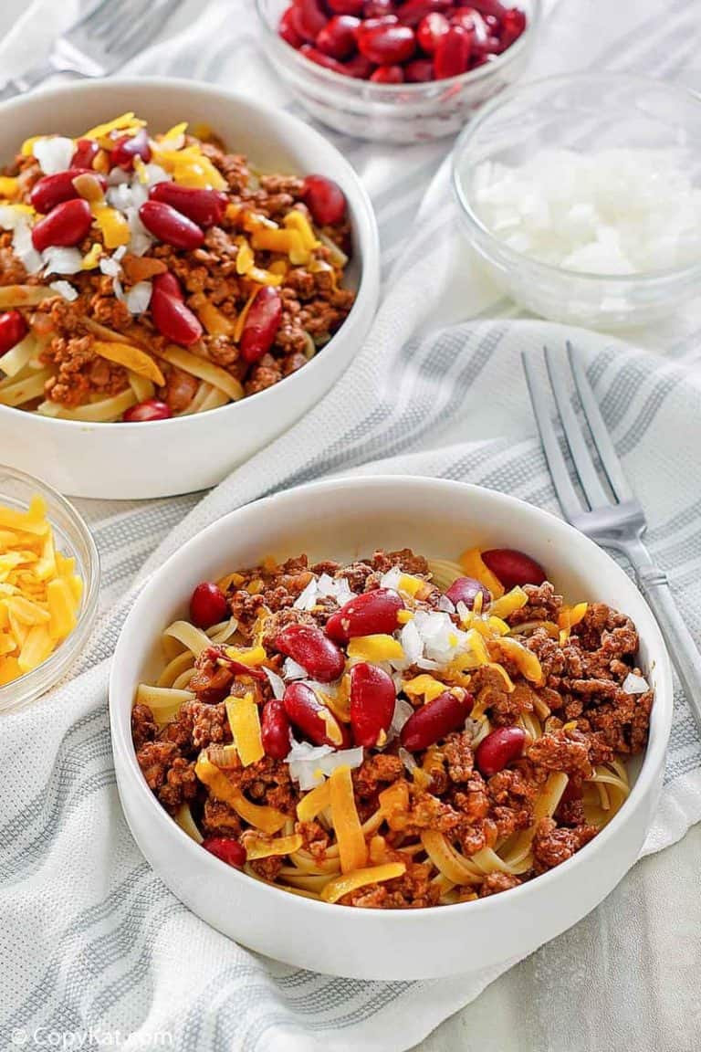 bowls of Cincinnati chili topped with cheese, onions, and kidney beans