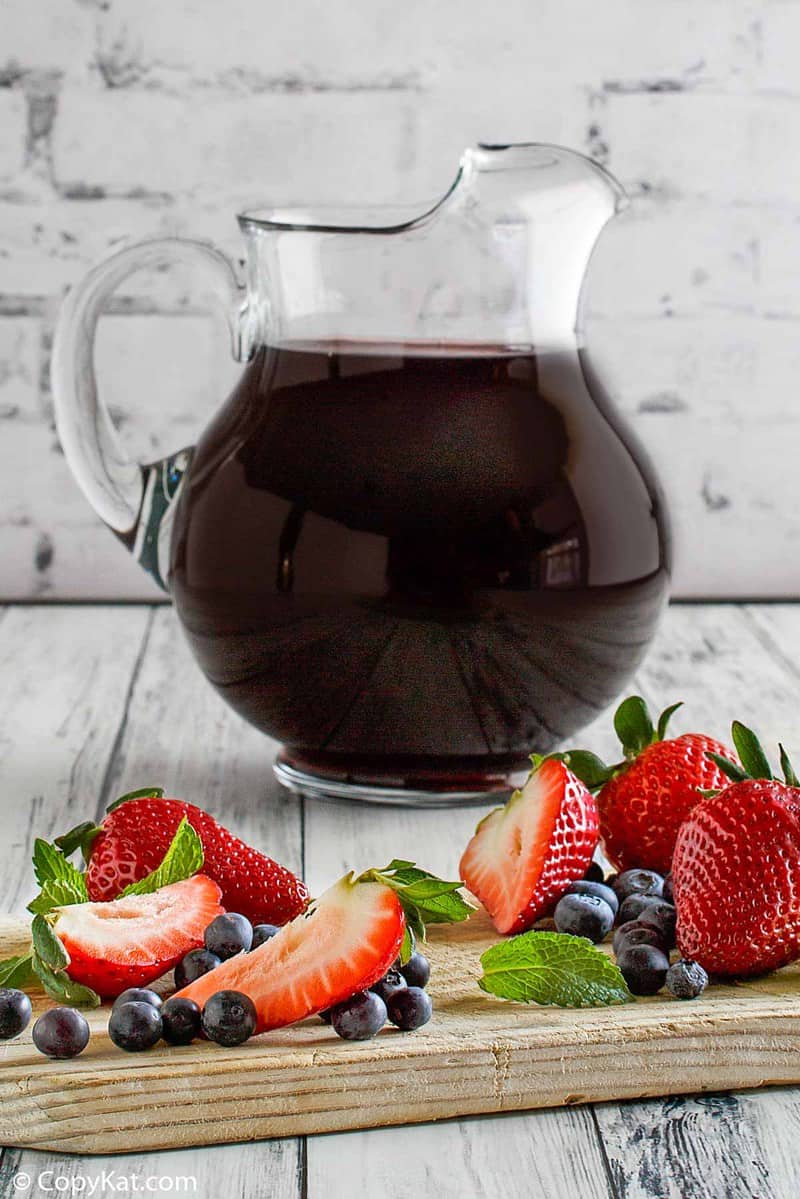 a pitcher of homemade Olive Garden Berry Sangria, strawberries, and blueberries