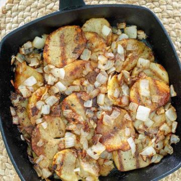 cooked sliced potatoes and onions in a skillet