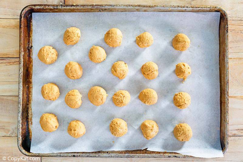 peanut butter balls on a parchment paper lined baking sheet