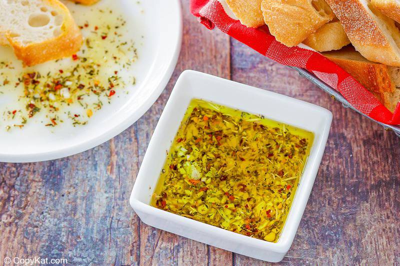 homemade Carrabba's Italian butter spicy Sicilian dipping sauce in a bowl and a basket of bread slices