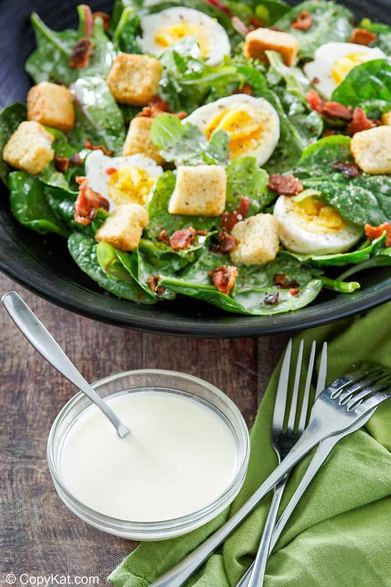 a bowl of homemade Commander's Palace salad dressing and a bowl of salad