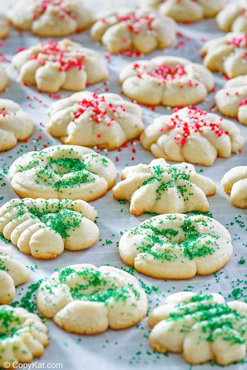 cream cheese spritz cookies scattered on parchment paper