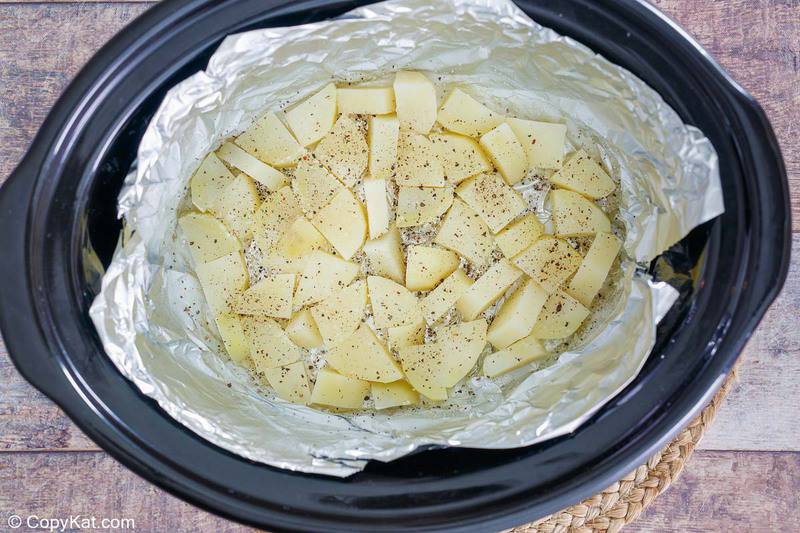 potato slices in a Crockpot slow cooker