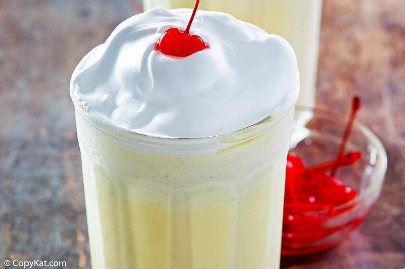 closeup of an eggnog shake with whipped cream and a cherry on top