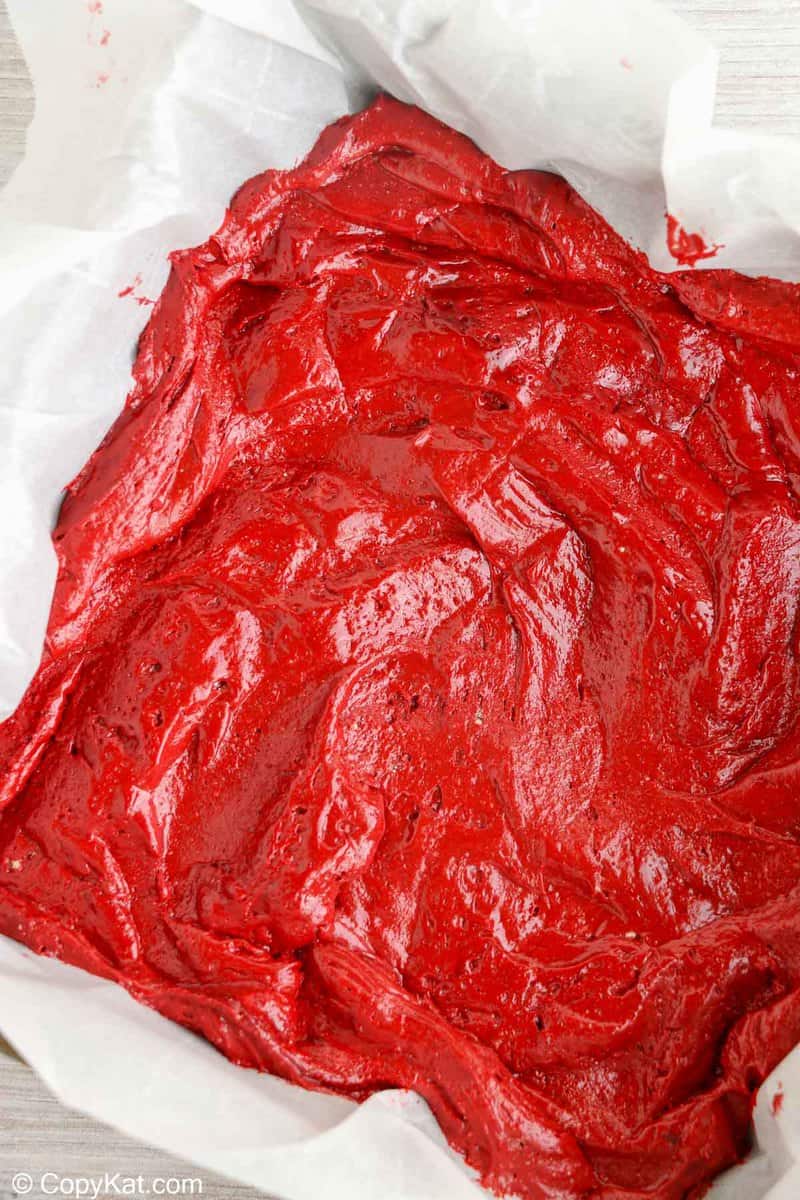 red velvet brownies batter in a parchment lined baking pan