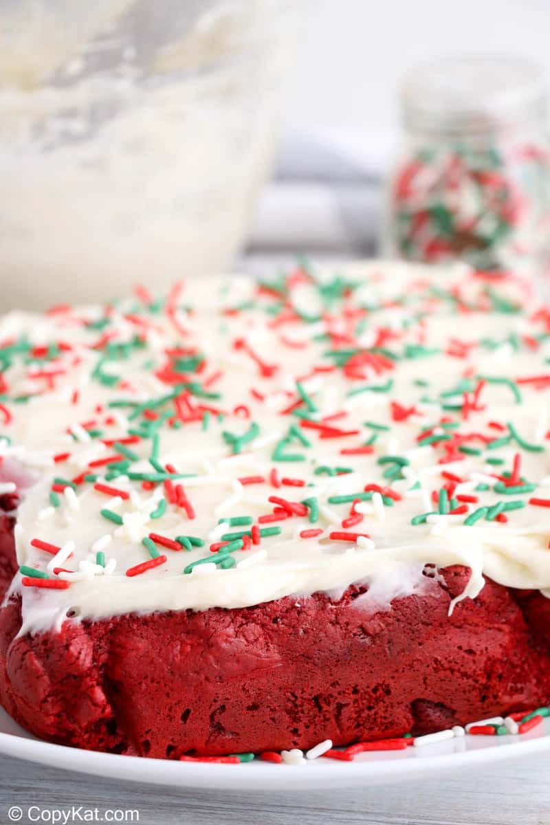 whole red velvet brownies with frosting and sprinkles before being sliced into pieces