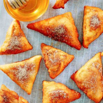 sopapillas and honey on parchment paper