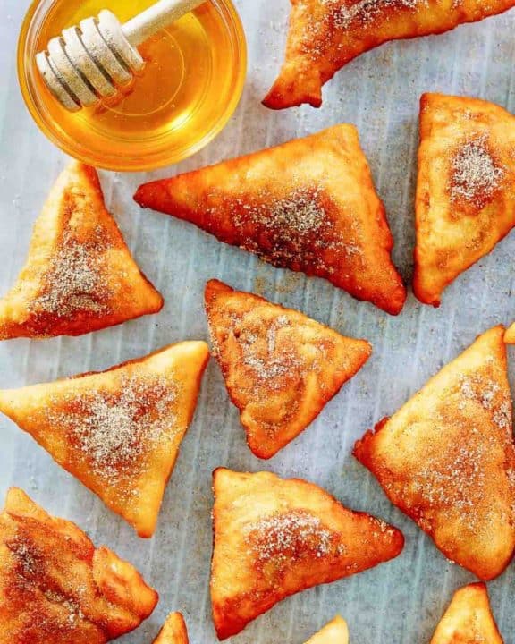 sopapillas and honey on parchment paper