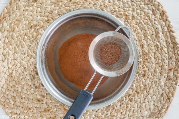 homemade Swiss Miss Hot Cocoa Mix being sifted into a bowl