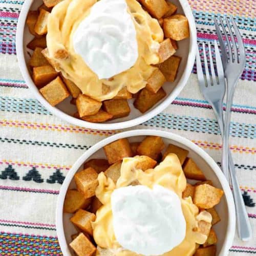 Overhead view of two bowls of homemade Taco Bell Cheesy Fiesta Potatoes