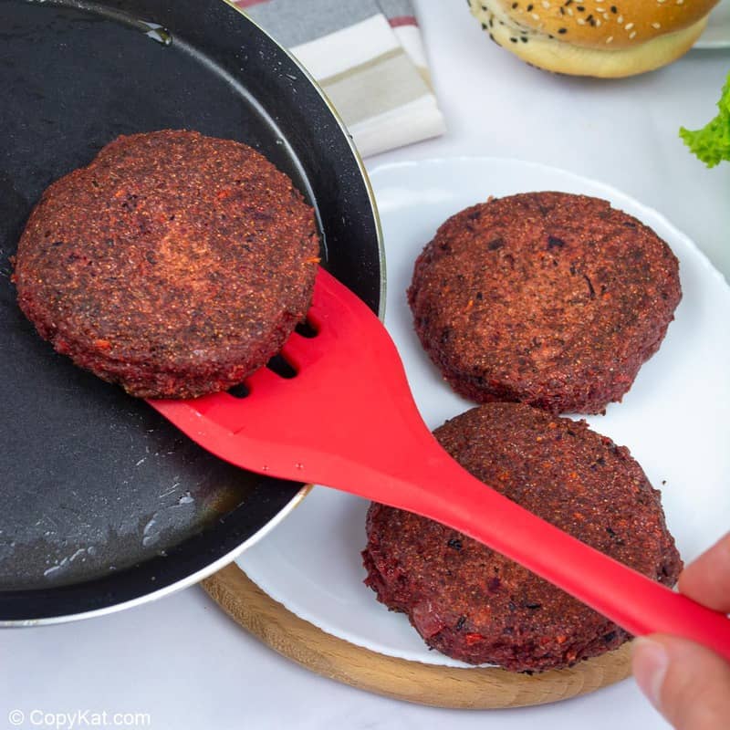 pan-fried vegan burger patties in a skillet and on a plate