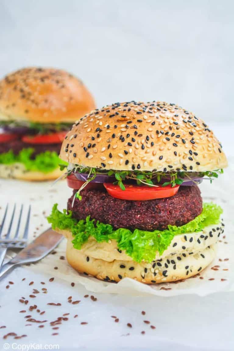 two vegan burgers with lettuce and tomato on sesame seed buns