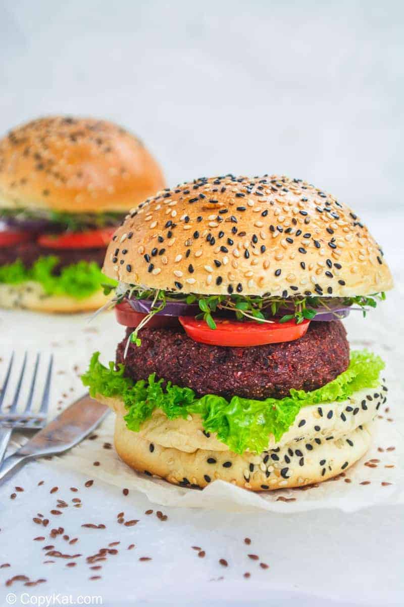 two vegan burgers with lettuce and tomato on sesame seed buns