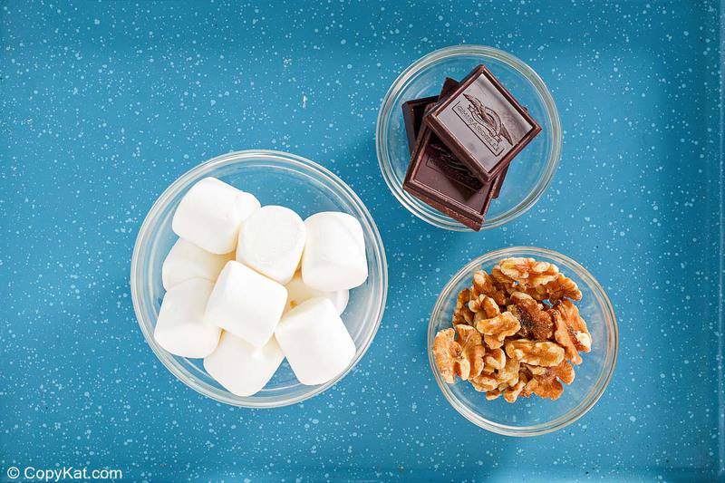 large marshmallows, chocolate pieces, and chopped walnuts in bowls