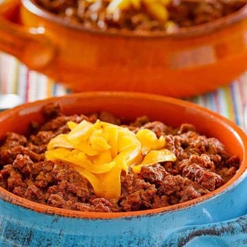 bowls of homemade Wick Fowler 2 Alarm Chili topped with cheese