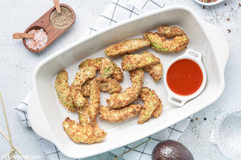 avocado fries and a bowl of ketchup in a serving dish