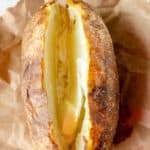 air fryer baked potato with butter on parchment paper