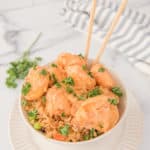 air fryer bang bang shrimp, sauce, rice, and chopsticks in a bowl