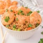 air fryer bang bang shrimp tossed with sauce over rice in a bowl