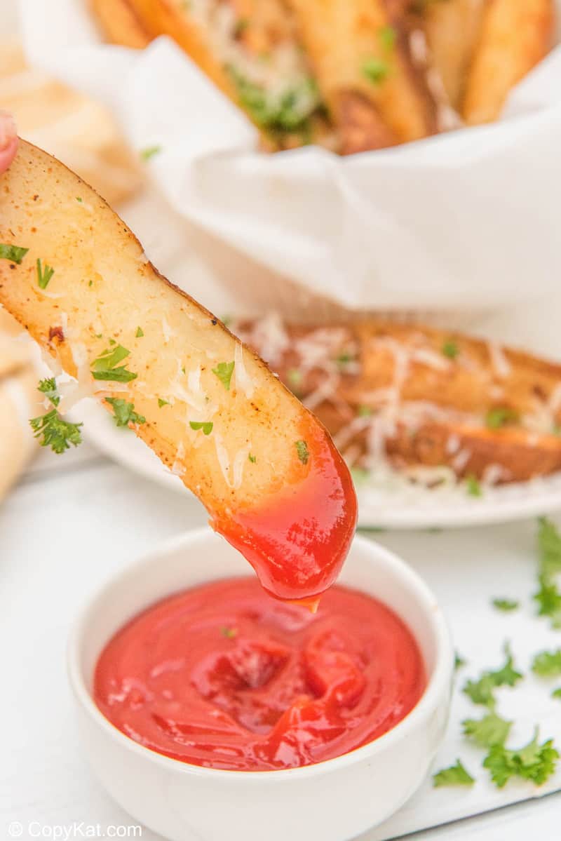 air fryer potato wedge dipped in ketchup