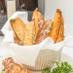 air fried potato wedges in front on an air fryer