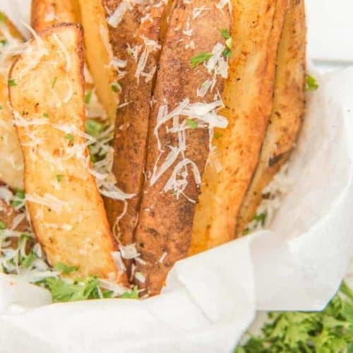 air fried potato wedges sprinkled with parmesan cheese in a serving dish