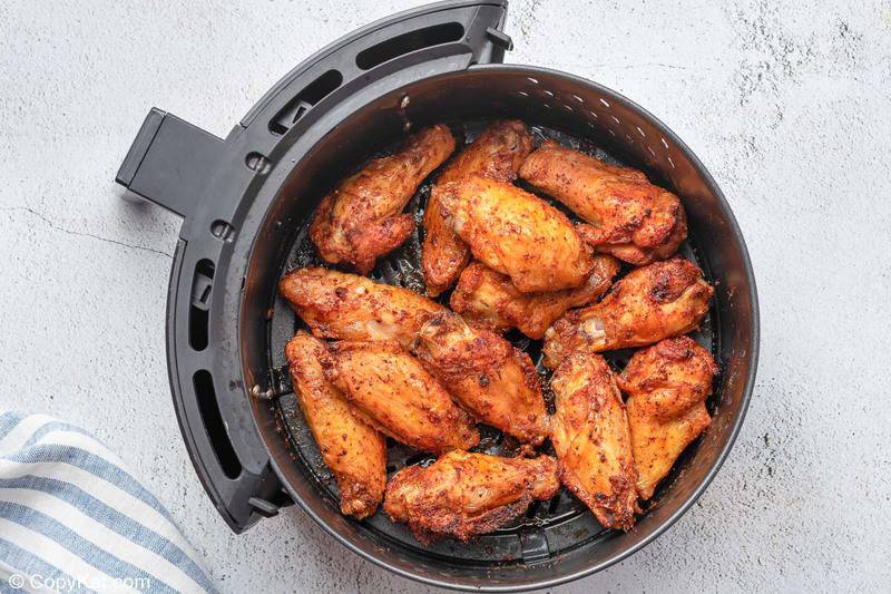 cooked sweet and spicy chicken wings in an air fryer basket